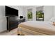 Cozy bedroom featuring a dresser, desk, and large windows offering views of the outside at 1821 Windsor Dr, Winter Park, FL 32789