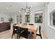 Bright dining area with wood table, black chairs, modern light fixture and natural lighting at 1821 Windsor Dr, Winter Park, FL 32789