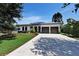Charming home featuring a two-car garage, solar panels, and well-manicured landscaping with a spacious driveway at 1821 Windsor Dr, Winter Park, FL 32789