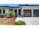 Inviting home exterior highlighting a two-car garage, stone accents, and landscaped garden with a paved walkway at 1821 Windsor Dr, Winter Park, FL 32789