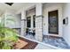Welcoming front porch with stone pillars, stylish seating, and a contemporary front door, creating curb appeal at 1821 Windsor Dr, Winter Park, FL 32789