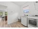 Bright laundry room with modern washer and dryer, utility sink, and wood-look tile flooring at 1821 Windsor Dr, Winter Park, FL 32789
