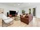 Spacious living room features a large leather couch, accent chair, and view to the back yard at 1821 Windsor Dr, Winter Park, FL 32789