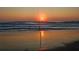 Golden sunset over the ocean at the beach with fishing pole in the sand at 2 Pirates Cv, Ormond Beach, FL 32176