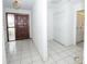 Bright tiled entryway featuring a wooden door, white brick wall and a closet at 2 Pirates Cv, Ormond Beach, FL 32176