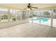 This is a bright, tiled sunroom leading to a screened-in pool area and overlooking the backyard at 2 Pirates Cv, Ormond Beach, FL 32176