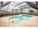 A large, inviting pool area with a built-in spa, surrounded by lush landscaping and a screened enclosure at 2 Pirates Cv, Ormond Beach, FL 32176