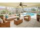 Digitally staged sunroom with tile flooring, neutral furnishings, and easy access to the pool area at 2 Pirates Cv, Ormond Beach, FL 32176