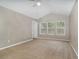 Bright, carpeted bedroom with ceiling fan, neutral walls, and well-lit by a trio of windows at 2110 Stockton Dr, Sanford, FL 32771