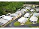 An aerial view reveals the layout of a manufactured home community along a waterfront at 229 Rue De Fontaine, Tavares, FL 32778