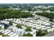 Wide aerial view of a retirement community with numerous residences and surrounding trees and a highway at 229 Rue De Fontaine, Tavares, FL 32778