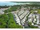 Aerial view of community homes on canals near a lake, surrounded by mature trees and lush landscaping at 229 Rue De Fontaine, Tavares, FL 32778