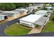 Aerial view of a cozy manufactured home with well-kept lawn, and covered parking at 229 Rue De Fontaine, Tavares, FL 32778