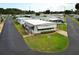 An aerial view shows a cozy home with a driveway, awning, landscaping, and surrounding community at 229 Rue De Fontaine, Tavares, FL 32778