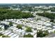 Wide aerial view of a retirement community with numerous residences and surrounding trees and a highway at 229 Rue De Fontaine, Tavares, FL 32778