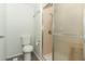 A bathroom features a toilet and a walk-in shower with a glass door at 229 Rue De Fontaine, Tavares, FL 32778