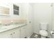A bathroom features a sink, toilet, and tiled walls with a neutral marble-look countertop at 229 Rue De Fontaine, Tavares, FL 32778