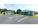 Exterior shot of the community center with ample parking and an American flag, showcasing community amenities at 229 Rue De Fontaine, Tavares, FL 32778