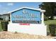 Community sign for an active adult 55+ community with meticulously maintained landscaping at 229 Rue De Fontaine, Tavares, FL 32778