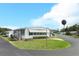 Well-maintained manufactured home with awnings and landscaped front yard in a vibrant 55+ community at 229 Rue De Fontaine, Tavares, FL 32778