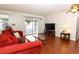 Comfortable living room with wallpapered walls, wood floors and a sliding door to the screened in porch at 229 Rue De Fontaine, Tavares, FL 32778