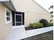 Enclosed back porch with neutral exterior paint, a screen door, and lush landscaping at 2299 Hawks Cove Cir, New Smyrna Beach, FL 32168