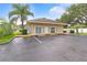 A clubhouse with parking in front on a sunny day with blue skies and green vegetation at 2299 Hawks Cove Cir, New Smyrna Beach, FL 32168