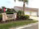 Hawks Cove community sign with a beautifully landscaped entrance and tan condos at 2299 Hawks Cove Cir, New Smyrna Beach, FL 32168