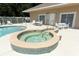 Outdoor hot tub spa with tile trim and a view of the community swimming pool and furniture at 2299 Hawks Cove Cir, New Smyrna Beach, FL 32168