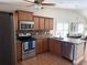 Open kitchen with stainless steel appliances, granite countertops, and wood cabinets at 2299 Hawks Cove Cir, New Smyrna Beach, FL 32168
