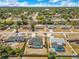 Expansive aerial view showcasing a neighborhood with tree-lined streets and several houses with screened-in pools at 2397 Albury Ave, Deltona, FL 32738