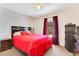 Comfortable bedroom featuring a ceiling fan, window with curtains, and a cozy bed with red cover at 2397 Albury Ave, Deltona, FL 32738