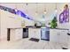 Bright kitchen features white cabinets, stainless steel appliances, and a unique, colorful accent wall and marbled tile floor at 2397 Albury Ave, Deltona, FL 32738