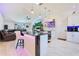 Open-concept living space with a kitchen island, large TV, and a comfortable leather sectional at 2397 Albury Ave, Deltona, FL 32738