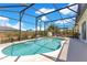Inviting screened-in pool with clear blue water, and a tranquil backyard setting with mature trees at 2397 Albury Ave, Deltona, FL 32738