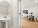 Stylish powder room with pedestal sink and oval mirror, located off of the dining area at 2949 Clever Ln, Winter Park, FL 32792