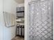 Bright bathroom featuring a shower with decorative curtain, shelves, and storage at 3216 Casa Del Rey Ave, Kissimmee, FL 34746