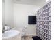 Well-lit bathroom with patterned shower curtain, toilet, sink, and a granite-style vanity at 3216 Casa Del Rey Ave, Kissimmee, FL 34746