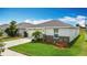 Well-maintained single-story home with a manicured front yard and a driveway leading to a two car garage at 3216 Casa Del Rey Ave, Kissimmee, FL 34746