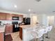 Kitchen with island, granite counters, black appliances, and seating area with white bar stools at 3216 Casa Del Rey Ave, Kissimmee, FL 34746