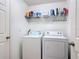 A functional laundry room, equipped with a washer, dryer and shelving at 3216 Casa Del Rey Ave, Kissimmee, FL 34746
