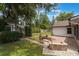 Backyard with brick paver patio, bench seating, manicured lawn, and detached shed at 352 Inglenook Cir, Winter Springs, FL 32708