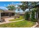 Expansive backyard featuring a brick patio, cozy fire pit, and a quaint shed adorned with greenery at 352 Inglenook Cir, Winter Springs, FL 32708