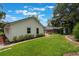 Backyard with manicured lawn and brick paver pathway leading to patio with seating at 352 Inglenook Cir, Winter Springs, FL 32708