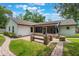 Backyard with brick paver patio, bench seating, manicured lawn, and covered porch at 352 Inglenook Cir, Winter Springs, FL 32708
