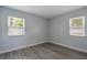 A cozy bedroom with gray walls, hardwood floors and two windows for plenty of light at 352 Inglenook Cir, Winter Springs, FL 32708