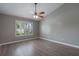 Bright bedroom boasts luxury vinyl plank flooring, large window with stylish shutters, and modern ceiling fan at 352 Inglenook Cir, Winter Springs, FL 32708