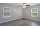 Bright bedroom featuring gray walls, hardwood floors, two windows and a ceiling fan at 352 Inglenook Cir, Winter Springs, FL 32708