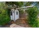 Charming backyard shed with a trellis, surrounded by vibrant greenery and brick pavers at 352 Inglenook Cir, Winter Springs, FL 32708