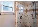 Shower features glass door, brown tiled walls, and rainfall shower head in updated bathroom at 352 Inglenook Cir, Winter Springs, FL 32708